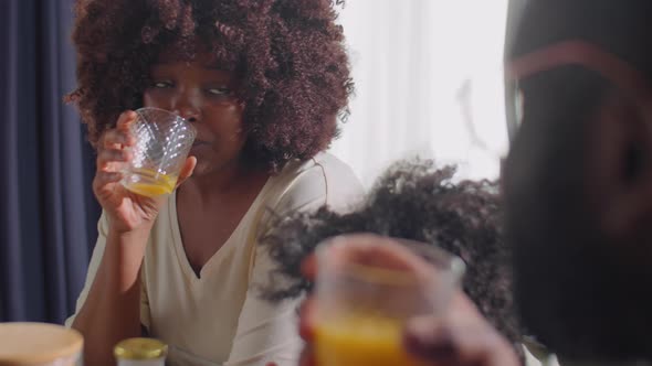 African American Woman Speaking with Family at Home Breakfast alt