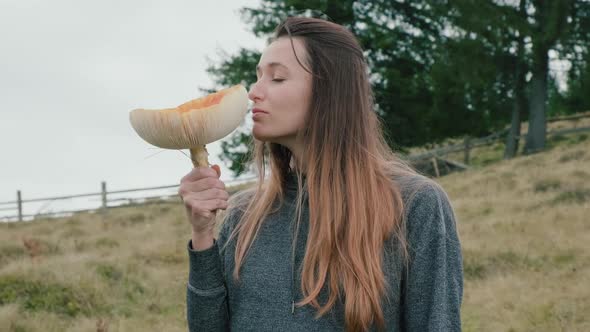Closeup Young Woman Sniffs Huge Toxic Fly Agaric Amanita on Autumn Day alt