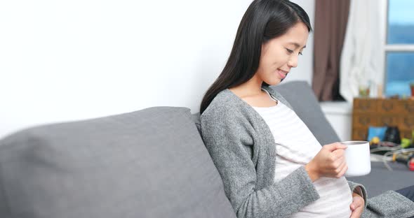 Pregnant woman drinking water alt
