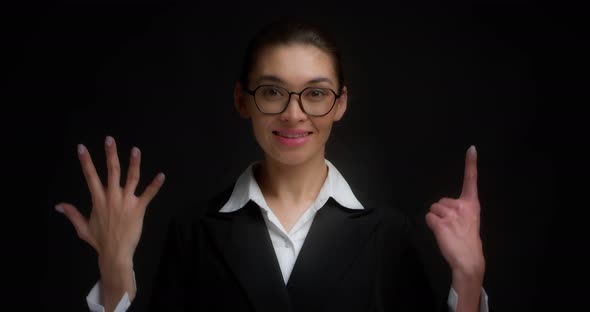 Asian Woman in Glasses Smiling and Shows Six Fingers with Her Hand
