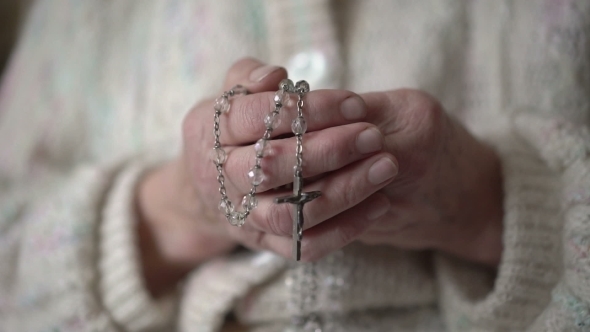 Old Wrinkled Hands Holding Rosary And Praying With Icon alt