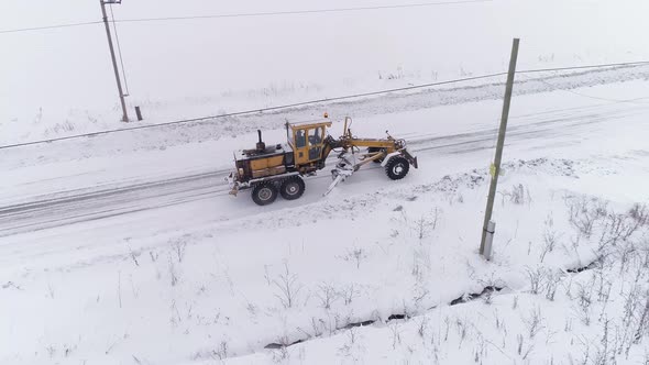 Aerial view of Snowblower Grader Clears Snow Covered Country Road in village 05 alt