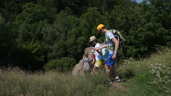 Group of Hikers Stepping Down Along Rocky Path alt