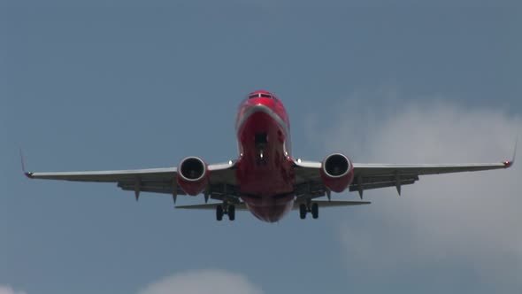 Red Passenger Jetliner Overhead Landing In Airport