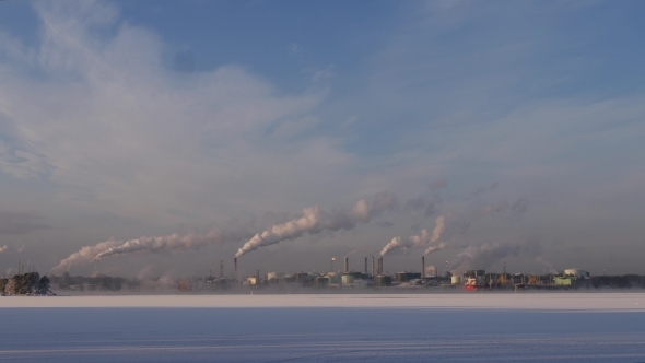 A Factory With Blowing Smoke From The Chimney