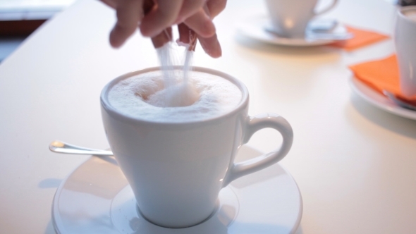 Female Hand With Cup Of Coffee In a Coffee Shop