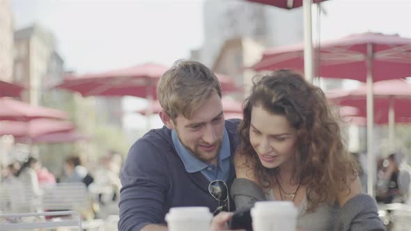Couple at outdoor cafe posing for selfie alt