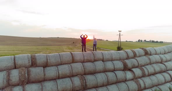 Agriculture Successful Farmers Standing on the Top of a Bale of Straw alt