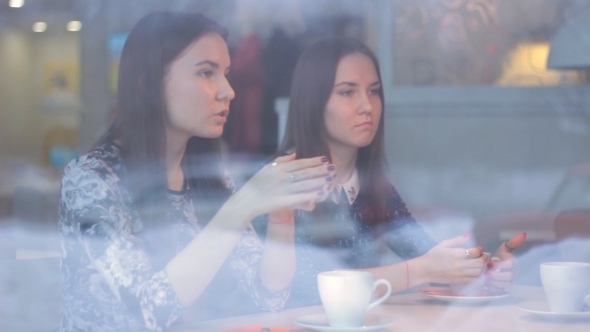 Twins Young Girls Talk In a Cafe In Winter