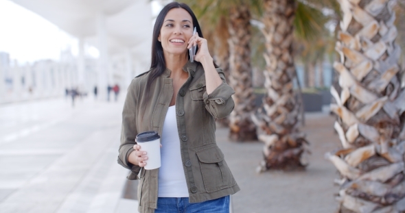 Attractive Woman Talking On a Mobile In a Park alt
