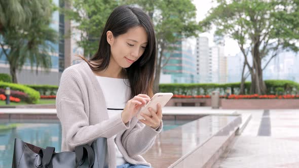 Woman working on mobile phone at outdoor alt