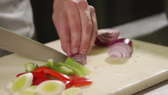 Close Up Shot of the Chef's Hands, He Cuts a Red Onion Into Pieces alt