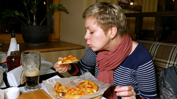 Pretty Blond Woman Eats Pizza And Drinks Beer