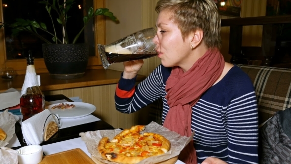 Pretty Blond Woman Eats Pizza And Drinks Beer