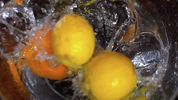 Lemons And Orange Falling Into Water