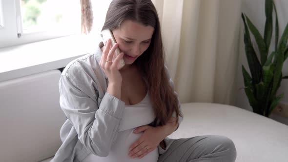 Happy Pregnant Woman with Tablet Have Video Call Using Smartphone Communicates with Husband Via Chat