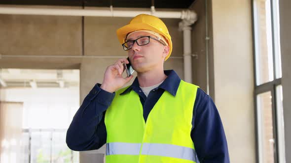 Male Builder Calling on Smartphone at Office