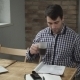 Attractive Man Drinking Coffee And Reading The Newspaper, Is On The Table Phone And a Laptop. - VideoHive Item for Sale