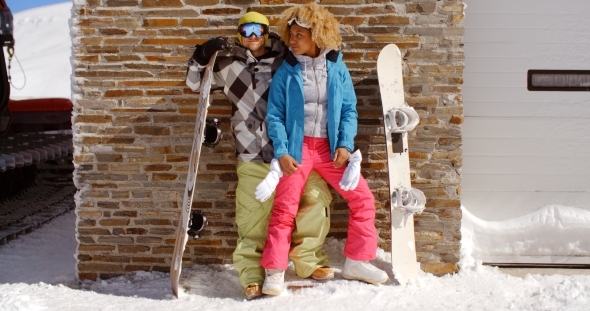 Close Couple Posing With Snowboards Against Garage alt