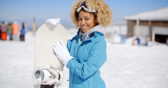 Happy Friendly Young Woman Posing With a Snowboard alt