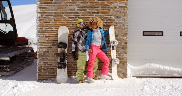 Cute Couple Leaning Against Ski Resort Garage alt