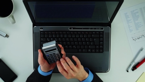 Businessman Using Calculator 