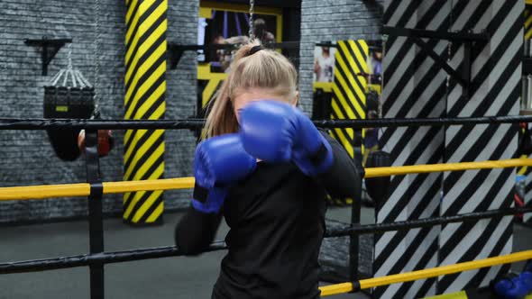 Young Athletic Boxer Girl Hits the Camera with a Glove