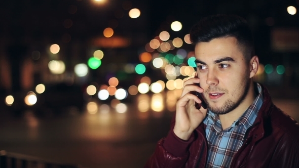 Young Man Calling On Mobile Phone At Night In City.