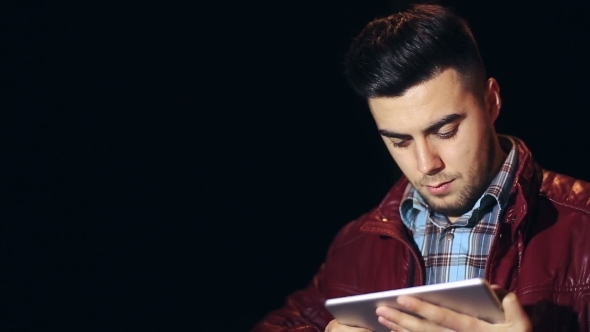 Young Caucasian Man With Tablet Computer In City At Night