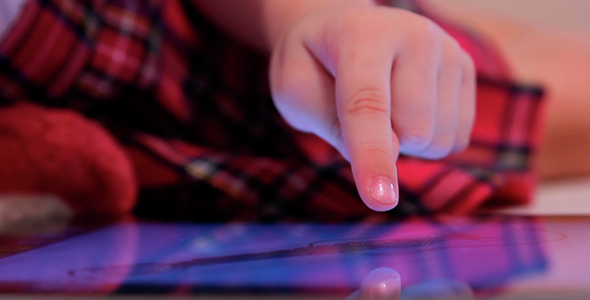 Little Girl Drives a Finger on the Screen of the Electronic Tablet