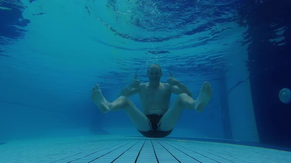 The Man Jumps Under the Water and Shows a Gesture That Everything Is Fine.  Underwater Shooting alt