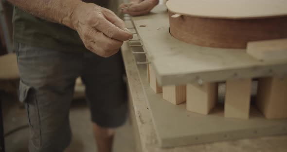 carpenter inserting nails into a board