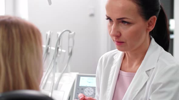 Dentist and patient having a conversation in dentist's office alt