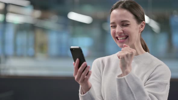 Portrait of Woman Celebrating on Smartphone alt