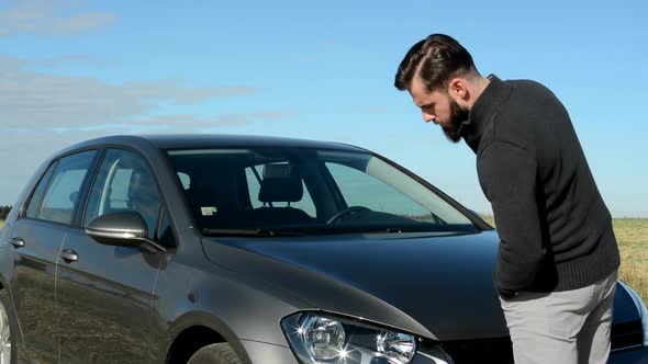 Young Handsome Man Monitor Condition of His Car Then Turn To the Camera and Smile - Eye Contact alt