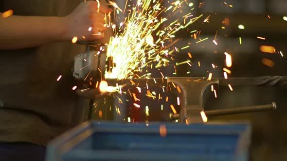 Factory Worker Using Electric Grinder alt