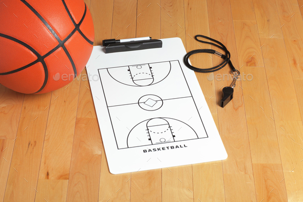 Basketball with Coach's Clipboard and Whistle on Wooden Floor