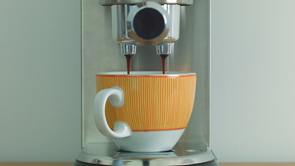 Making Americano Coffee Using the Espresso and Cappuccino Machine in a Orange Cup