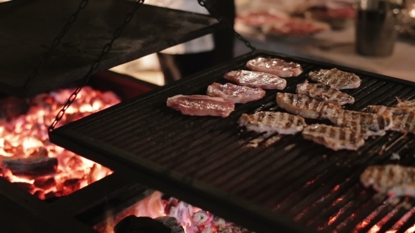 Cook Prepares Steaks On The Grill