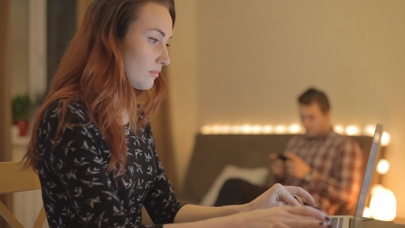 Beautiful Girl Works At a Laptop At Home