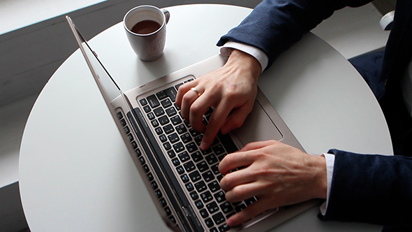 Man Working On Laptop And Drinking Coffee alt