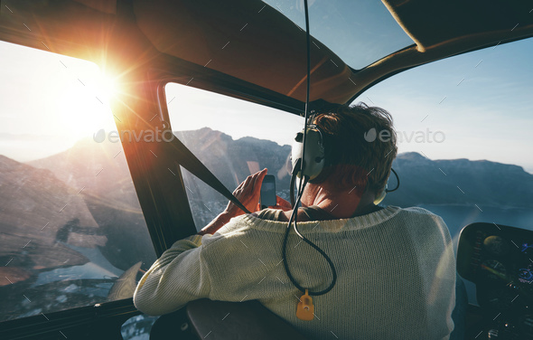 Female tourist on helicopter tour taking pictures
