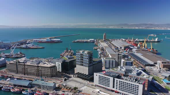 Orbiting around the harbor district at noon, boats and ocean in background.