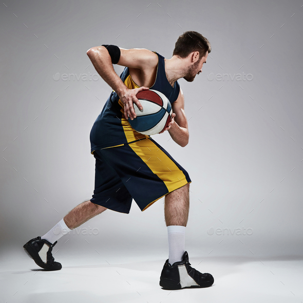 Full length portrait of a basketball player with ball - Stock Photo - Images