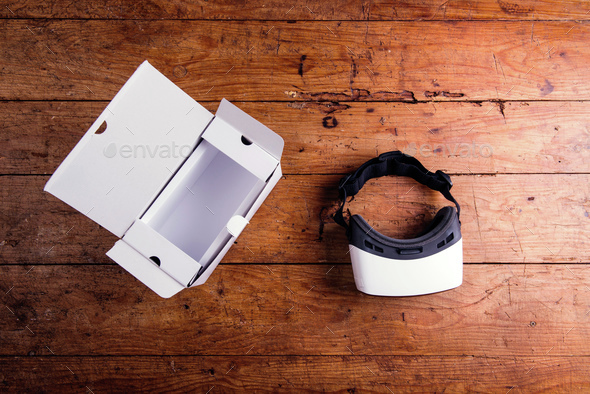 Virtual reality goggles with paper box on wooden table - Stock Photo - Images