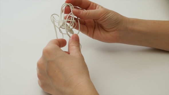 Woman Untangles Tangled Earbuds Or Earphone Knot 