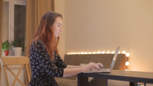 Young Woman Working At a Laptop At Home