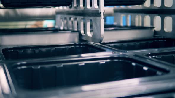 Close Up View of Plastic Containers Being Manufactured alt