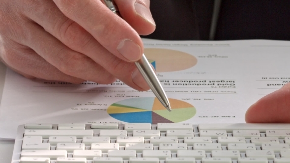 Businessman's Hand Showing Diagram On Report With Pen.