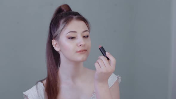 Attractive Young Woman Paints Her Lips with Lipstick Looking in the Mirror Happy Beautiful Lady Does